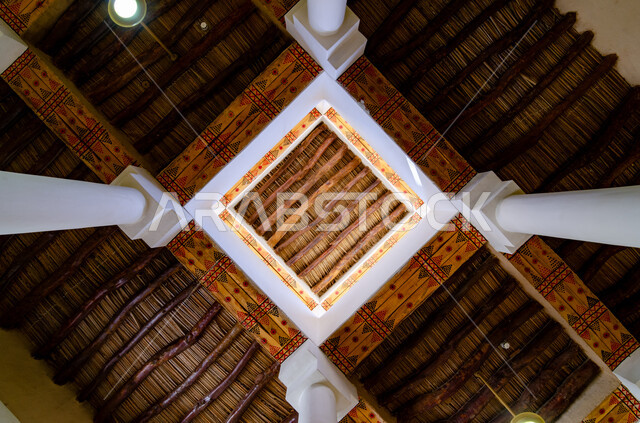 Colorful Najdi engravings and decorations on wood, arts and architectural designs for old-style mud buildings, archaeological sites in Saudi Arabia, a picture from below of the roofs of the historic Murabba Palace in the city of Riyadh, antiquity and adherence to Saudi heritage, famous tourist places.
