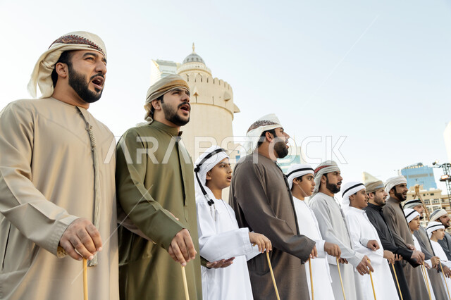 التعبير عن الانتماء والفخر بالهوية الوطنية, مجموعة من الرجال العرب الخليجيين الاماراتيين يرتدون الزي الاماراتي يغنون في مهرجان الحصن التقليدي, الفعاليات والأنشطة الترفيهية في مدينة أبوظبي، الرقص الشعبي في المهرجانات التراثية