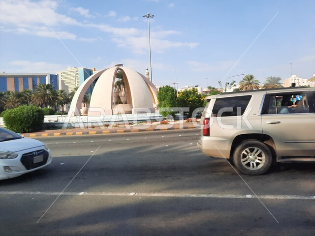 دوار الدوارق والمسجمات الكبيرة في الساحات العامة، معالم واماكن اسلامية دينية مقدسة, الاهتمام بزراعة الأشجار والنباتات الخضراء في مكة المكرمة، حركة السيارات في الطرقات والشوارع المعبدة في المملكة العربية السعودية وضح النهار 