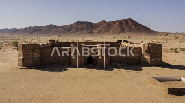 القلاع الاثرية القديمة في منطقة تبوك، التشكلات والتكوينات الصخرية في الصحراء العربية، القمم والمرتفعات الجبلية في المناطق البرية، صورة جوية علوية لقلعة الأزنم في محافظة ضباء في وضح النهار، أماكن طبيعية سياحية في المملكة العربية السعودية