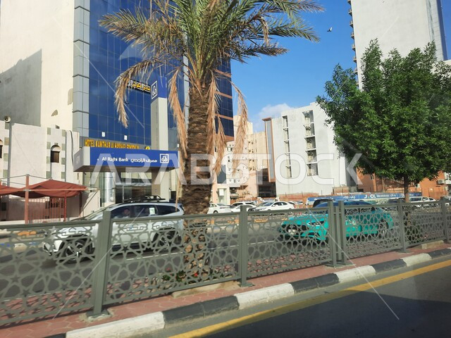 Interest in planting trees and green plants in Mecca, Prince Muhammad bin Salman bin Abdulaziz Road, sacred Islamic religious landmarks and places, car traffic on paved roads and streets in the Kingdom of Saudi Arabia, luxury hotels and towers surrounding the Grand Mosque