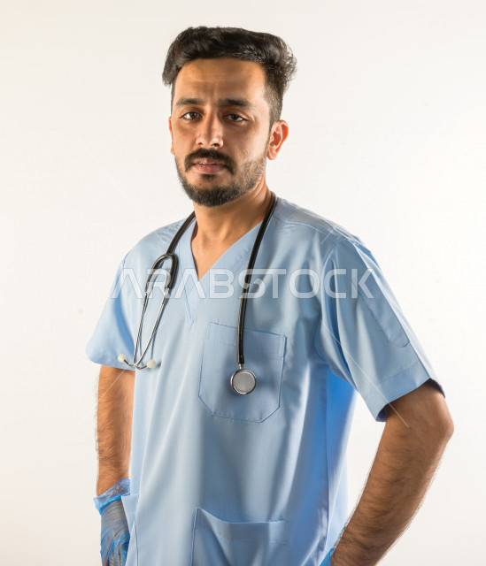 بورتريه لطبيبب سعودي خليجي مبتسم و ينظر للكاميرا ، يقدم خدماته للمرضى بكل كفاءه  ، خلفية بيضاء، مفهوم الطب والرعاية الصحية