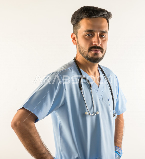 بورتريه لطبيبب سعودي خليجي مبتسم و ينظر للكاميرا ، يقدم خدماته للمرضى بكل كفاءه  ، خلفية بيضاء، مفهوم الطب والرعاية الصحية