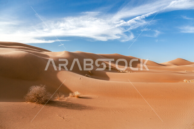 السحب البيضاء في السماء فوق التلال والكثبان الرملية في وضح النهار، التضاريس الطبيعيه في صحراء منطقة تبوك في المملكة العربية السعودية، الرمال الناعمة الذهبية، أماكن سياحية طبيعية، خلفية الطبيعه الصحراوية