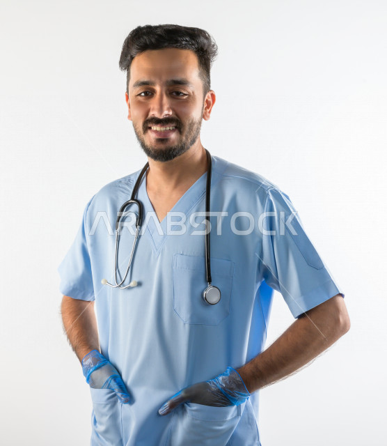 بورتريه لطبيبب سعودي خليجي مبتسم و ينظر للكاميرا ، يقدم خدماته للمرضى بكل كفاءه  ، خلفية بيضاء، مفهوم الطب والرعاية الصحية