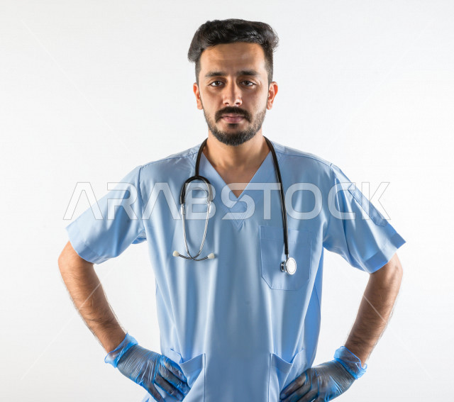 بورتريه لطبيبب سعودي خليجي مبتسم و ينظر للكاميرا ، يقدم خدماته للمرضى بكل كفاءه  ، خلفية بيضاء، مفهوم الطب والرعاية الصحية