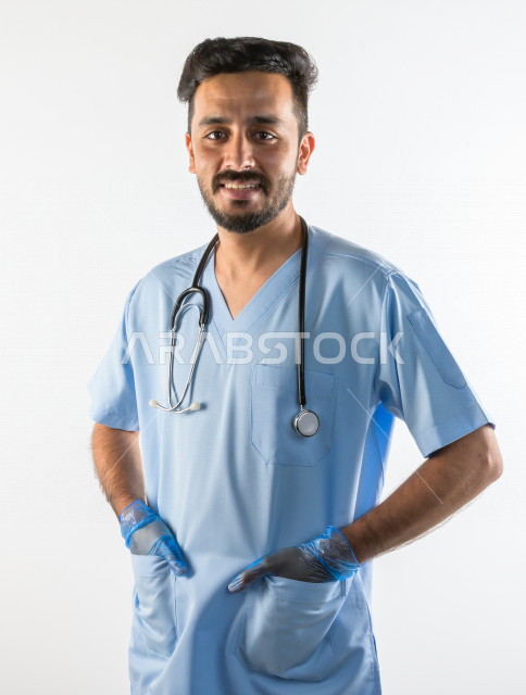 بورتريه لطبيبب سعودي خليجي مبتسم و ينظر للكاميرا ، يقدم خدماته للمرضى بكل كفاءه  ، خلفية بيضاء، مفهوم الطب والرعاية الصحية
