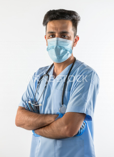 طبيبب سعودي يرتدي الكمامة ، اتباع اجراءات السلامة ، يقدم خدماته للمرضى بكل كفاءه  ، خلفية بيضاء، مفهوم الطب والرعاية الصحية