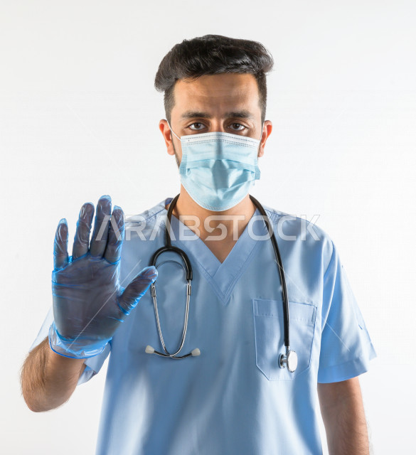 طبيبب سعودي يرتدي الكمامة ، اتباع اجراءات السلامة ، يقدم خدماته للمرضى بكل كفاءه  ، خلفية بيضاء، مفهوم الطب والرعاية الصحية