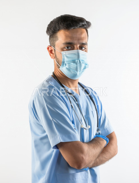 طبيبب سعودي يرتدي الكمامة ، اتباع اجراءات السلامة ، يقدم خدماته للمرضى بكل كفاءه  ، خلفية بيضاء، مفهوم الطب والرعاية الصحية