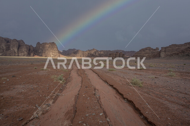 التكوينات والتشكيلات الصخرية في المملكة العربية السعودية، الاستمتاع بالمناظر الطبيعية، مشهد قوس قزح خلف السلسة الجبلية في مدينة تبوك الصحراوية، معالم سياحية مشهورة, التضاريس والنحت الصخري في المناطق المرتفعة، طريق رملي وسط الصحراء