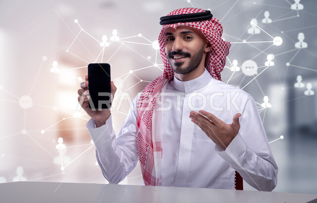 عرض شاشة سوداء فارغة، تطور التكنولوجيا الرقمية، صورة مقربة لرجل اعمال عربي خليجي سعودي يرتدي الشماغ والثوب التقليدي يحمل بيده الهاتف الجوال، الذكاء الاصطناعي وتكنولوجيا المستقبل، خلفية أيقونات هولوجرامية ثلاثية الابعاد