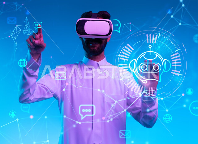 النقر والتفاعل مع الايقونات الهولوجرامية ومحاكاة العالم الخيالي، بورتريه مقرب لشاب عربي خليجي سعودي مبتسم يرتدي الزي التقليدي ونظارة الواقع الإفتراضي ثلاثية الأبعاد بايماءات اللمس  والاندماج مع التقنيات الثري دي، أجهزة الكترونية حديثة، خلفية زرقاء