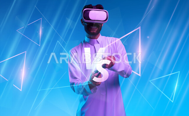 دمج المتعة والتسلية مع العالم الافتراضي، بورتريه مقرب لشاب عربي خليجي سعودي يرتدي الثوب التقليدي ونظارة الفي آر يمسك بيده عصا التحكم يقوم باللعب في ألعاب الفيديو الترفيهية، قضاء اوقات فراغ ممتعة، أجهزة تكنولوجية وتقنيات حديثة، خلفية زرقاء مع اشارة التحدي
