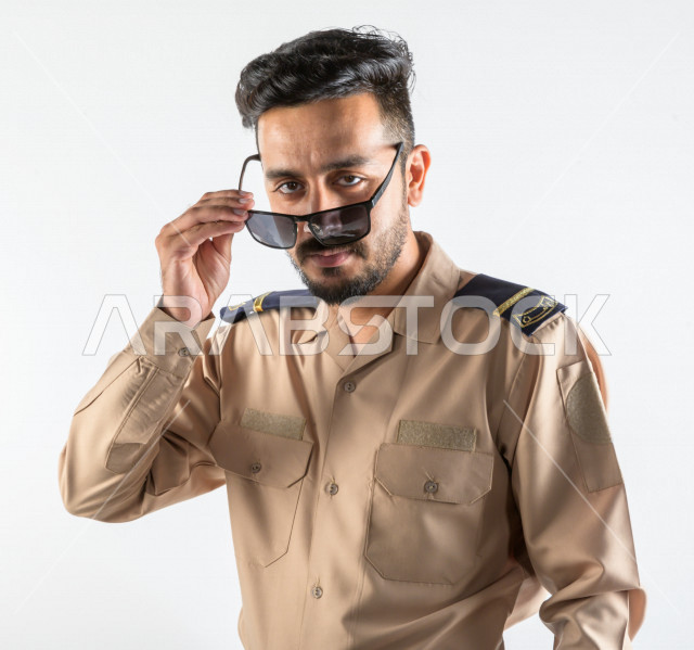 بورتريه لرجل سعودي خليجي يعمل كرجل أمن ، يرتدي الزي الرسمي للعمل ، الحفاظ على الامن و الطمأنينة ، حراسة و امان ، خلفية بيضاء
