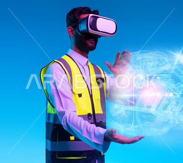العمل بالقطاع الهندسي عبر تقنية الواقع الافتراضي، استخدام خاصية الهولوجرام ثلاثية الأبعاد، بورتريه مقرب لمهندس عربي خليجي سعودي يرتدي سترة الحماية ونظارة الفي آر، رؤية مستقبلية 2030، استخدام التكنولوجيا في المجالات الهندسية، التفاعل مع الأيقونات الافتراضية، خلفية زرقاء