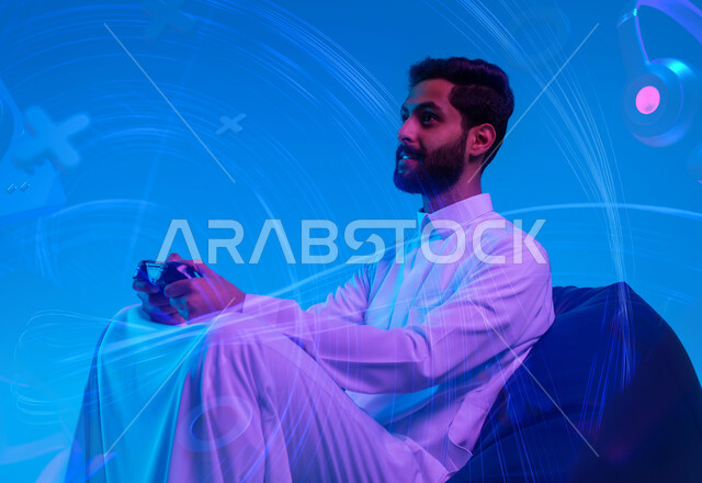 Fun and entertainment in video games, spending free time playing recreational electronic games, a portrait of a smiling Saudi Gulf Arab young man wearing a traditional dress, sitting on a comfortable chair, holding a joystick in his hand and raising his fist upwards with winning gestures, a blue background with navigation button icons.
