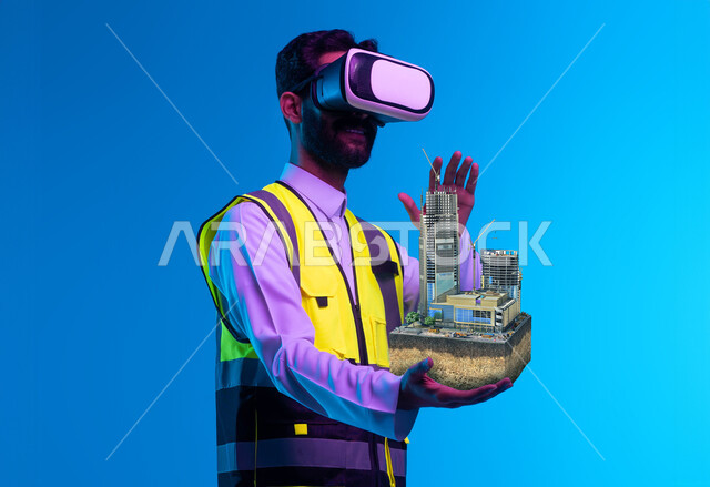 Interaction with virtual engineering, a close-up portrait of a Saudi Gulf Arab engineer wearing a helmet, work jacket, and virtual reality glasses holding a miniature model of towers, future vision 2030, growth and development of the engineering field through VR glasses, use of technology in engineering fields, blue background