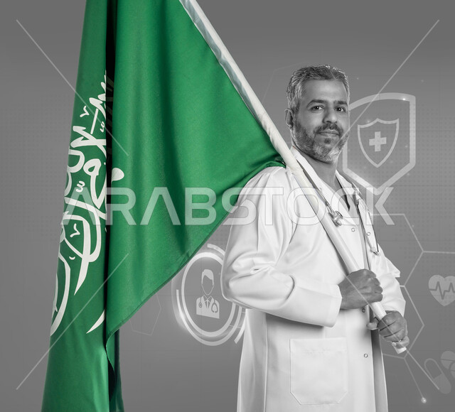 العمل في المجال الصحي, تقديم الخدمات الطبية, مهن ووظائف سعودية, صورة بالأبيض والأسود لطبيب عربي خليجي سعودي يرتدي المعطف الطبي الأبيض وسماعة الفحص يمسك علم المملكة بفخر, التعبير عن الانتماء للوطن في العيد الوطني 23 سبتمبر, يوم العلم 11 مارس, خلفية رموز طبية