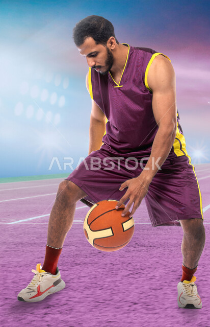 اتقان الحركات البطولية، شاب عربي خليجي سعودي يرتدي الملابس الرياضية يقوم بممارسة هواية كرة السلة، تمارين بدنية للتسليه والترفيه، أنشطة رياضية شبابية في السعودية، جودة الحياة الصحية، مفهوم اللياقة والمرونة، خلفية الملعب