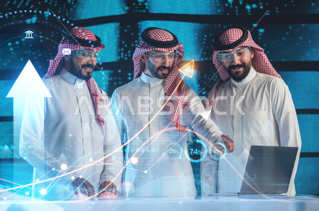 شركات التقنية والتكنولوجيا في السعودية, مجموعة من رجال أعمال عرب سعوديين خليجيين مبتسمين يرتدون الزي التقليدي ونظارات ثري دي يقومون بمتابعة الأسهم ومؤشرات البورصة عبر الحاسب المحمول, خلفية شاشات هولوجرامية ثلاثية الأبعاد مع أيقونات مؤشرات الربح والنسب المئوية