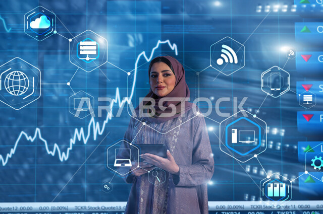 Reading the news summary using a tablet device, explaining the changes occurring in the prices of oil commodities and wealth, a Saudi Gulf Arab broadcaster and media personality wearing the hijab and abaya who presents economic news bulletins, a modern electronic screen background for the rise and fall of the stock index and the stock exchange.