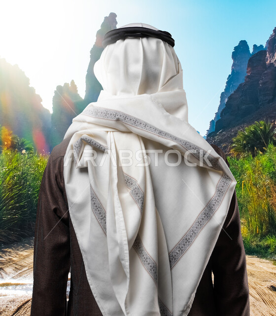 الأشجار والنباتات الخضراء، الوقوف بثقة واستقامة، صورة مقربة من الخلف لرجل عربي خليجي سعودي يرتدي الثوب والغترة التقليدية يقف في الحديقة، مفهوم الاناقة والاهتمام بالمظهر الخارجي، حدائق ترفيهية في السعودية