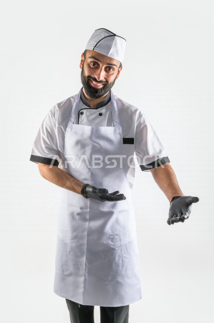 بورتريه لشيف طباخ سعودي خليجي خبير و ناجح  في العمل، يعمل في مجال الطبخ و الفندقة ، يرتدي الزي الرسمي الخاص بمزاولة مهنة الطباخ ، خلفية بيضاء