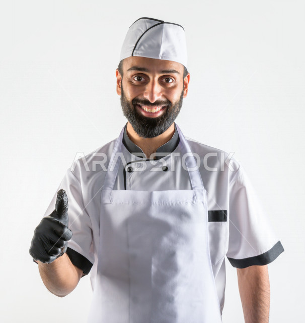 Portrait of an expert and successful Saudi Gulf chef at work, working in the field of cooking and hospitality, wearing the uniform for practicing the profession of cook, white background