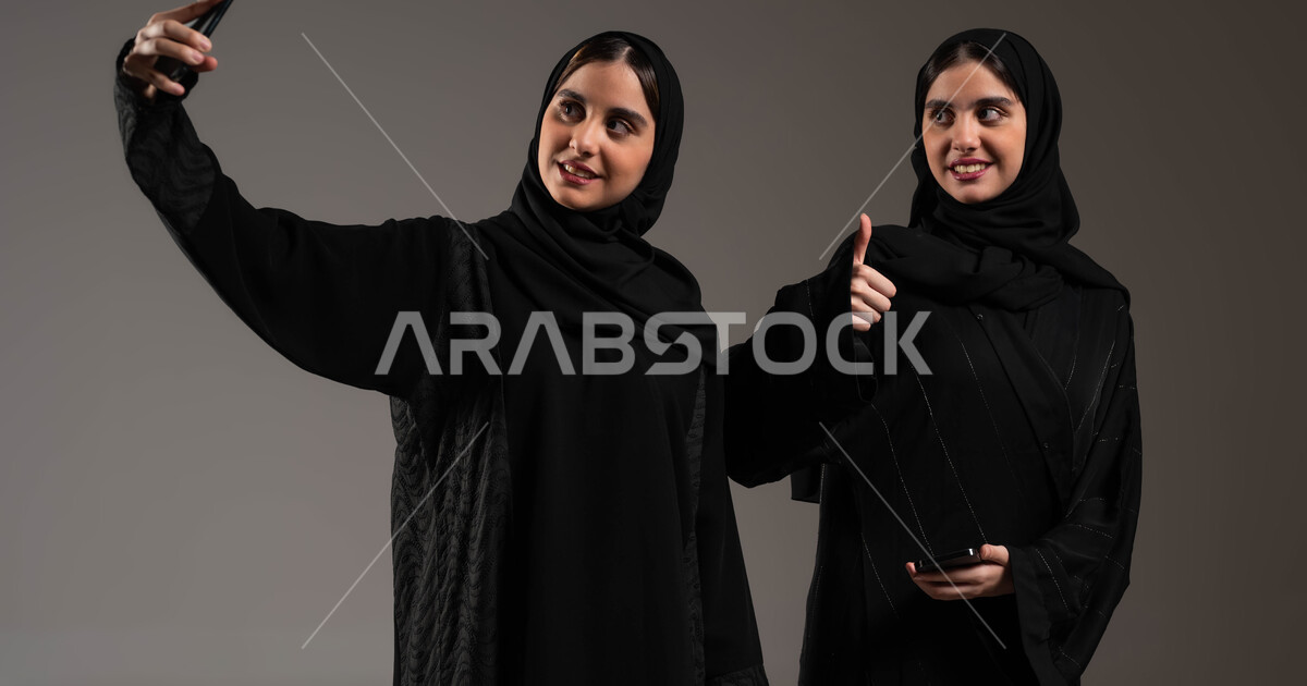 استخدام الجوال لالتقاط صور سيلفي تذكارية، بورتريه مقرب لبنتان توءم ...