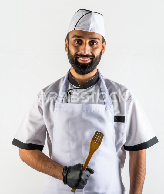 بورتريه لشيف طباخ سعودي خليجي خبير و ناجح  في العمل، يعمل في مجال الطبخ و الفندقة ، يرتدي الزي الرسمي الخاص بمزاولة مهنة الطباخ ، خلفية بيضاء