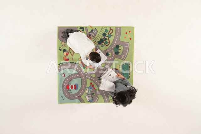 قضاء أوقات الفراغ بالاستمتاع بالرسم والتلوين, ممارسة هواية القراءة, تنمية المهارات الحركية والفنية ودعم المواهب,  مشاركة النشاطات الترفيهية مع الأخوات, بورتريه علوي عامودي لأخوين عربيين خليجيين سعوديين يجلسان على سجادة بتصميم عصري, خلفية بيضاء