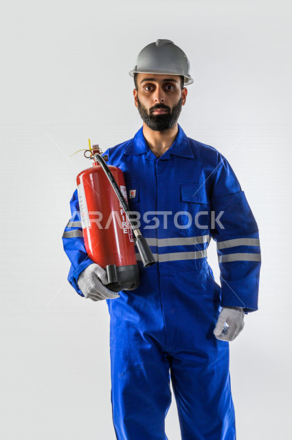 بورتريه لرجل اطفاء  سعودي خليجي ناجح ، معدات الازمة لاطفاء الحريق  ، يعمل في مجال الانقاذ ، يرتدي الزي الرسمي الخاص بمزاولة مهنة الدفاع المدني ، خلفية بيضاء