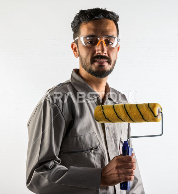 بورتريه لشاب سعودي خليجي يعمل كمهندس فني ، يزاول مهنته باحتراف ، المهارة و اتقان العمل ، عامل دهان محترف ، حرفي دهان ، ادوات التشطيب ، خلفية بيضاء