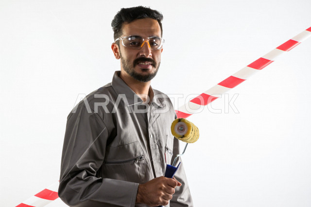 بورتريه لشاب سعودي خليجي يعمل كمهندس فني ، يزاول مهنته باحتراف ، المهارة و اتقان العمل ، عامل دهان محترف ، حرفي دهان ، ادوات التشطيب ، خلفية بيضاء