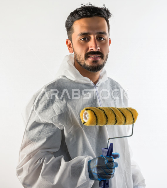 Portrait of a young Saudi Gulf man who works as a technical engineer, practicing his profession professionally, with skill and mastery of work, professional paint worker, paint craftsman, finishing tools, white background
