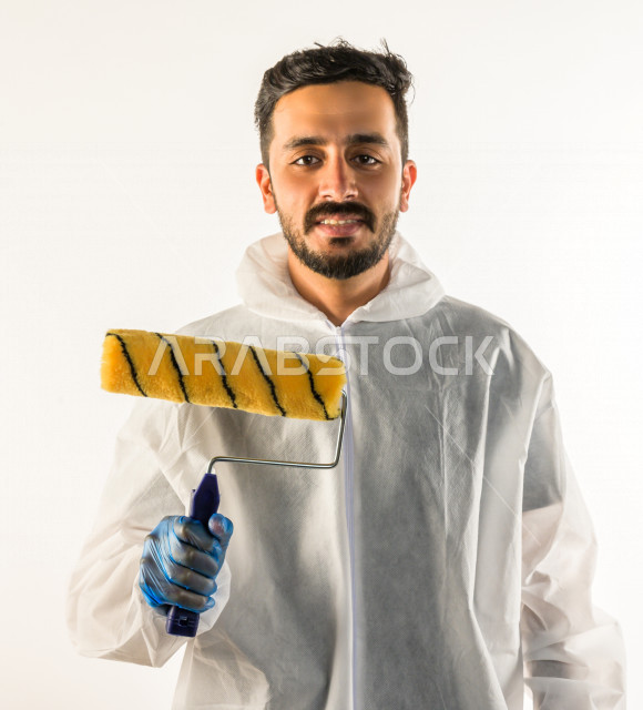 Portrait of a young Saudi Gulf man who works as a technical engineer, practicing his profession professionally, with skill and mastery of work, professional paint worker, paint craftsman, finishing tools, white background