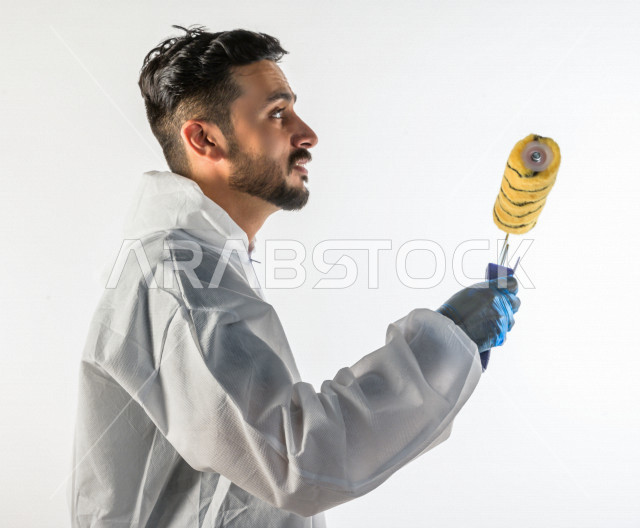 Portrait of a young Saudi Gulf man who works as a technical engineer, practicing his profession professionally, with skill and mastery of work, professional paint worker, paint craftsman, finishing tools, white background