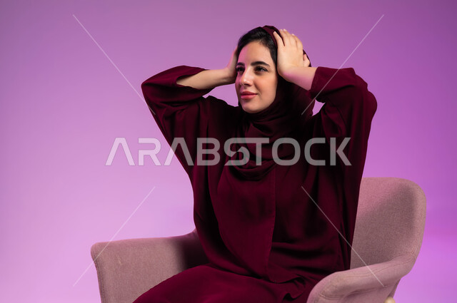 أوجاع وآلام الرأس, الاحساس بالصدمة والفشل, الشعور بالحزن لخسارة شيء ما, الحاجة إلى الهدوء والراحة, بورتريه مقرب لشابة عربية خليجية سعودية ترتدي العباءة الملونة والحجاب تضع يدها على رأسها, خلفية وردية