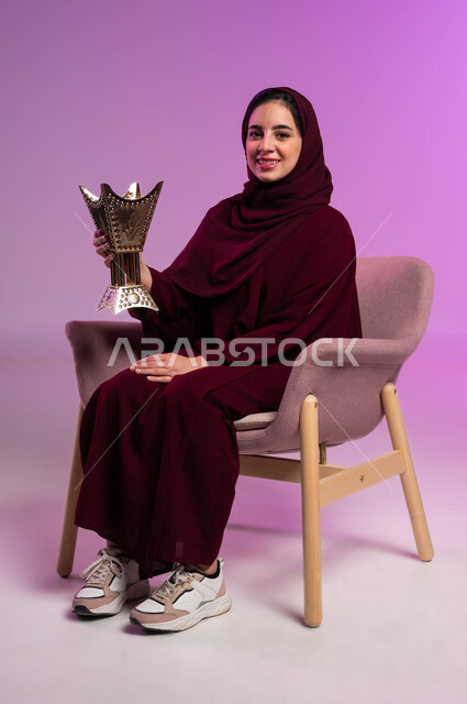 استخدام خشب العود بالأعياد والمناسبات, العادات والتقاليد السعودية, التطيب بالعود والبخور, بورتريه لشابة عربية خليجية سعودية ترتدي العباءة الملونة والحجاب تقوم بالتعطر من حامل البخور,  خلفية وردية