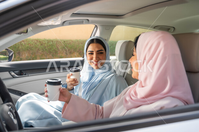 تبادل الأحاديث بإيماءات السرور، مفهوم الاستقلال و الاعتماد على النفس في وسائل النقل، تناول المشروبات الساخنه، التجول في شوارع المملكة ،قضاء أوقات ممتعه مع الأصدقاء، حرية القيادة للنساء السعوديات، صديقتان عربيتان خليجيتان سعوديتان محجبتان تجلسان في مقعد السيارة