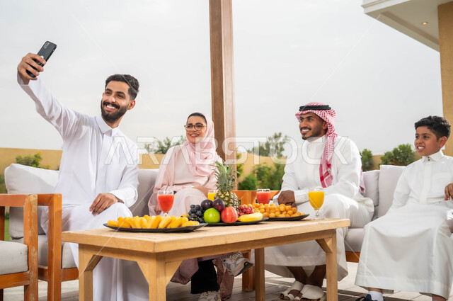 الاستمتاع في العطلة الصيفيه مع الاسرة، ايماءات السرور أثناء توثيق اللحظات السعيدة بالتقاط الصور التذكارية عبر الجوال، عائلة عربيه خليجيه سعودية تقضي أوقات الفراغ في إحدى الشاليهات، التنزه في الهواء الطلق