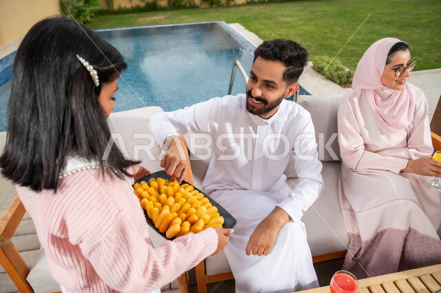 حسن الضيافه والاستقبال وإكرام الضيف, لمة الأسرة السعيدة في إحدى الشاليهات، فتاة عربيه خليجيه سعودية تقوم بتقديم حلا بلح الشام، أجواء مليئة بالحب والمودة، مفهوم صلة الرحم والاهتمام والاعتناء بالأهل