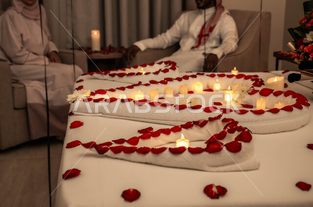 تبادل الأحاديث والتسامر بين الزوجين، تزيين غرفة النوم بطريقة رومانسية، احتفالات بذكرى الزواج، صورة مقربة لسرير مزين بالشموع والورود الحمراء للاحتفال بيوم الفلنتاين، الاهتمام بالمناسبات الخاصة.