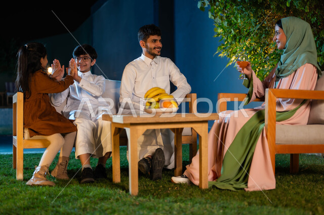 قضاء أوقات ممتعة برفقه الأهل في أوقات الفراغ في إحدى الشاليهات، جلسات وناسة عائلية، الترفيه والتسليه في الهواء الطلق، مفهوم العائله السعوديه المترابطه، أسرة عربيه خليجيه سعودية تقوم بتبادل الاحاديث والدردشات بإيماءات السرور، الاهتمام بالعائلة و مشاركتهم اللحظات السعيدة