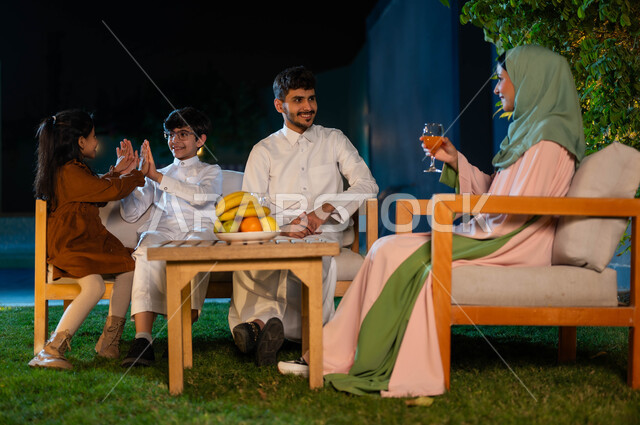 جلسات وناسة عائلية، الترفيه والتسليه في الهواء الطلق، مفهوم العائله السعوديه المترابطه، قضاء أوقات ممتعة برفقه الأهل في أوقات الفراغ في إحدى الشاليهات، أسرة عربيه خليجيه سعودية تقوم بتبادل الاحاديث والدردشات بإيماءات السرور، الاعتناء والاهتمام بالأولاد