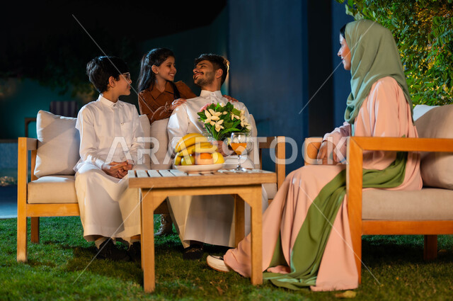 أب يحمل بيده باقة من الورود وينظر إلى ابنته بايماءات الحب والفرح، مفهوم الأسرة السعيدة، شاليهات راقية في المملكة العربية السعودية، قضاء أوقات مسلية برفقة العائلة