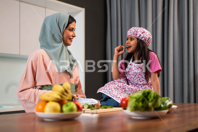 تحضير الوجبات الصحية المفيدة، مشاركة الاطفال في الطهي، تربيه الأطفال على حب التعاون،  تقطيع الخضراوات الطازجة الخضراء، الإستمتاع بأداء الأعمال المنزليه برفقة الأبناء، المساعده في إعداد الطعام، أم عربية خليجية سعودية تقف مع ابنتها في المطبخ