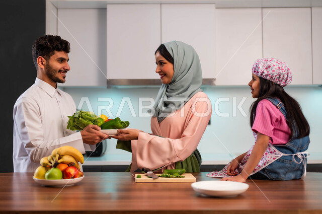 إعداد وصفات الطبخ بأجواء مميزة وممتعة، مشاركة العائلة تحضير الطعام، اجتماع العائله العربيه السعوديه الخليجيه في داخل المطبخ، إعداد مأكولات صحية طبيعية، ايماءات السعادة والسرور، مفهوم الأسرة السعيدة المتعاونة