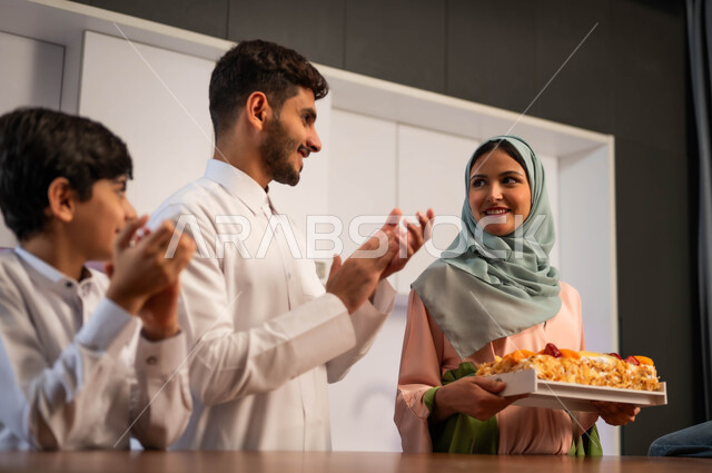 التصفيق للوالده لاعداد كعكة منزليه شهيه, صنع  الحلويات في المناسبات السعيده , التقدير و الشكر  للأم وتشجيعها, اجتماع العائله العربيه السعوديه الخليجيه في داخل المطبخ